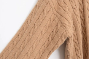 Close-up detail of the classic cable-knit texture on this light brown wool sweater