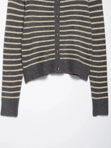 Detail of striped knit cardigan with gold buttons and ribbed texture for women