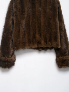 Detail of dark brown faux fur jacket showing plush texture and vertical striped pattern