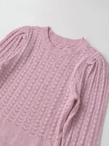 Détail d'un pull en maille rose clair pointelle avec texture ajourée et col rond
