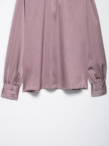 Détail d'une chemise en satin avec poignets plissés et texture sergé fine en rose poudré