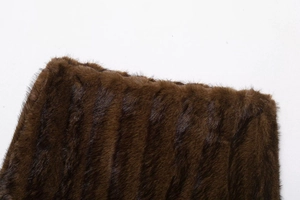 Close-up of deep brown faux fur texture with vertical stripes on high-end jacket