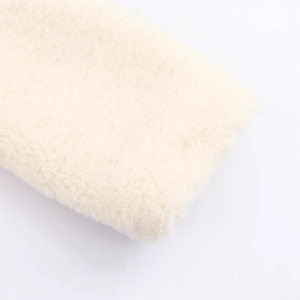 Close-up of soft faux shearling coat texture in cream white with plush fur finish