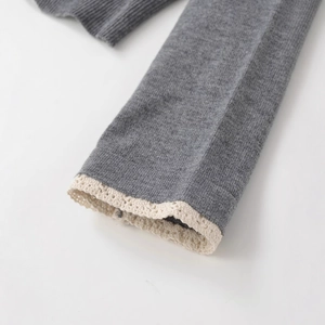 Graue Strickjacke mit zarten cremefarbenen Häkelspitzen-Details an den Ärmeln