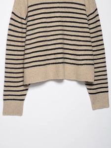 Detail of khaki striped knit sweater with black stripes and ribbed cuffs for women