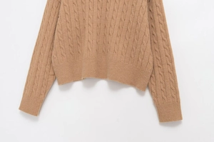 Detailed cable knit pattern on camel long sleeve sweater with ribbed cuffs and hem
