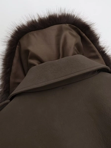 Close-up of brown jacket featuring a detachable faux fur collar and textured leather