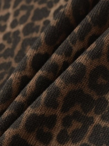 Close-up of leopard print knit fabric texture showing weave detail and soft material