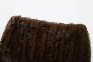 Detailed close-up of dark brown faux fur fabric with dense stripes and glossy texture