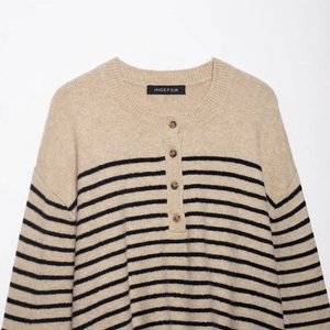 Oatmeal striped knit sweater with black horizontal lines and a buttoned crew neck collar