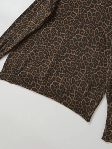 Close-up of animal leopard print knit fabric with ribbed edges and soft texture