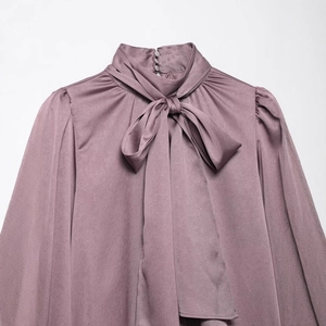 Chemisier élégant en satin violet à manches longues avec col à nœud papillon et plis
