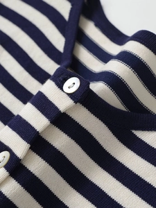 Gros plan sur le gilet en maille rayée bleu marine et beige avec boutons en nacre