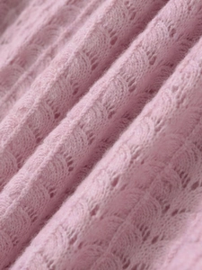 Vue détaillée du tricot rose clair ajouré avec une texture élégante de crochet ondulé