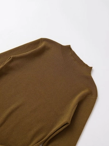 Detailed close-up of the knitted mock neck collar and roll-edge texture on a brown sweater