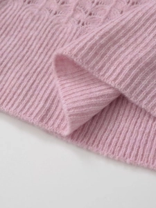 Gros plan d'un pull en maille rose montrant la texture mohair et les détails au crochet