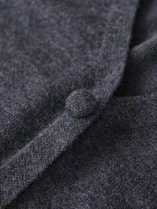 Détail macro du cardigan en maille gris anthracite avec boutons recouverts de fil