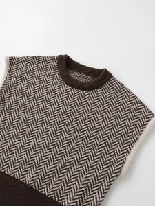 Detail of brown herringbone knit vest featuring ribbed crew neck and textured pattern