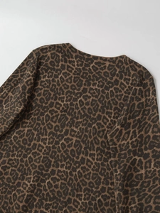 Detail of the crew neck and classic brown leopard print texture on a long sleeve knit top