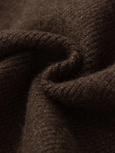 Close-up of thick dark brown knit fabric showing soft texture and premium wool fibers
