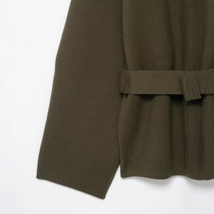 Cardigan in maglia verde oliva con cintura, focus su texture di manica e vita