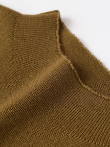 Detail view of brown rib-knit fabric texture with fine decorative stitching on the edge