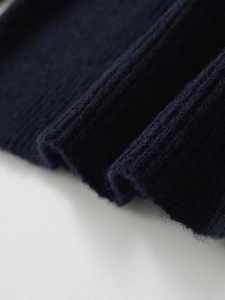 Detailed macro view of dark blue ribbed alpaca wool knit fabric with soft texture