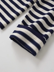 Détail de la manche d'un cardigan en maille à rayures bleu marine et blanc