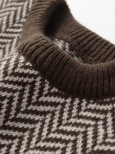 Detailed close-up of brown and white herringbone knit pattern on a crew neck vest top