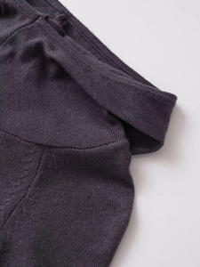 Detailed close-up of the dark grey knitted dress neckline and soft fabric texture