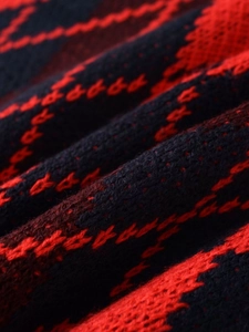Gros plan sur la texture du tricot jacquard à motifs de losanges rouges et noirs de qualité