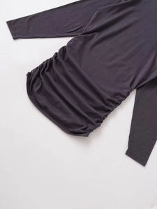 Detail view of ruched waist design on a slim-fit dark grey knitted long sleeve dress