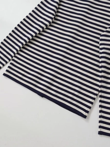 Détail d'un cardigan en tricot rayé bleu marine et blanc avec coutures de qualité