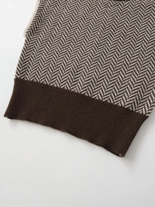 Macro shot of brown herringbone knit vest featuring detailed ribbed hem and soft texture