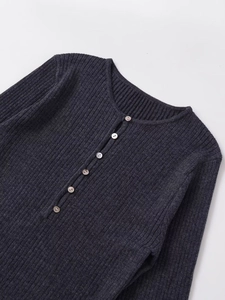 Détail de la texture en maille côtelée gris foncé et de l'encolure boutonnée du pull
