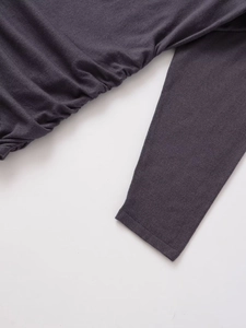 Detail view of dark grey long sleeve knit dress with ruched side and fine texture