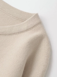 Detaillierte Nahaufnahme von Rundhals und Waffelstrick-Struktur am beige Pullover