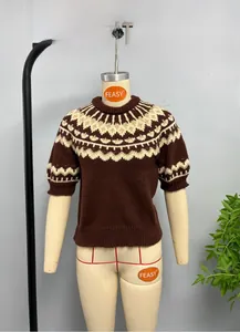 Detail view of retro jacquard pattern and ribbed cuffs on brown knit sweater