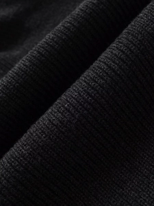 Macro shot of high-quality black rib-knit fabric texture on asymmetric cape cardigan