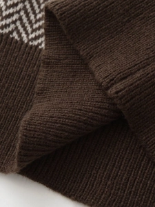 Detail of dark brown knit vest showing chunky ribbed texture and white houndstooth pattern