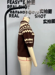 Detailed view of dark brown knitted sweater with Nordic geometric pattern on the neckline