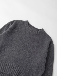 Close-up of the ribbed crew neck and fine knit texture of this dark grey wool sweater
