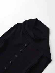 Detail of black ribbed knit cardigan featuring large scarf collar and gray buttons