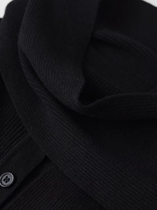 Detail view of black ribbed knit fabric with a classic four-hole button closure