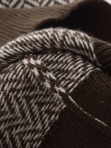 Macro shot of brown and white herringbone knit fabric texture with soft wool fibers
