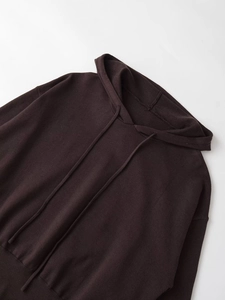 Detail of dark coffee knitted hoodie showing fine texture and ribbed hem detail