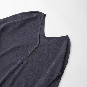 Gilet en maille gris foncé avec col en V et boutons sur le devant sur fond blanc