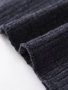 Vue macro de la maille côtelée gris foncé montrant les détails du tissu artisanal