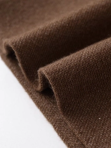 Detail shot of brown knit fabric texture showing premium soft weaving craft and fibers