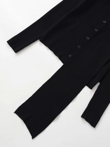 Detailed view of black ribbed knit cardigan and matching pants with button closure